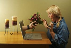 Hand and Flowers Coming Through Laptop Screen